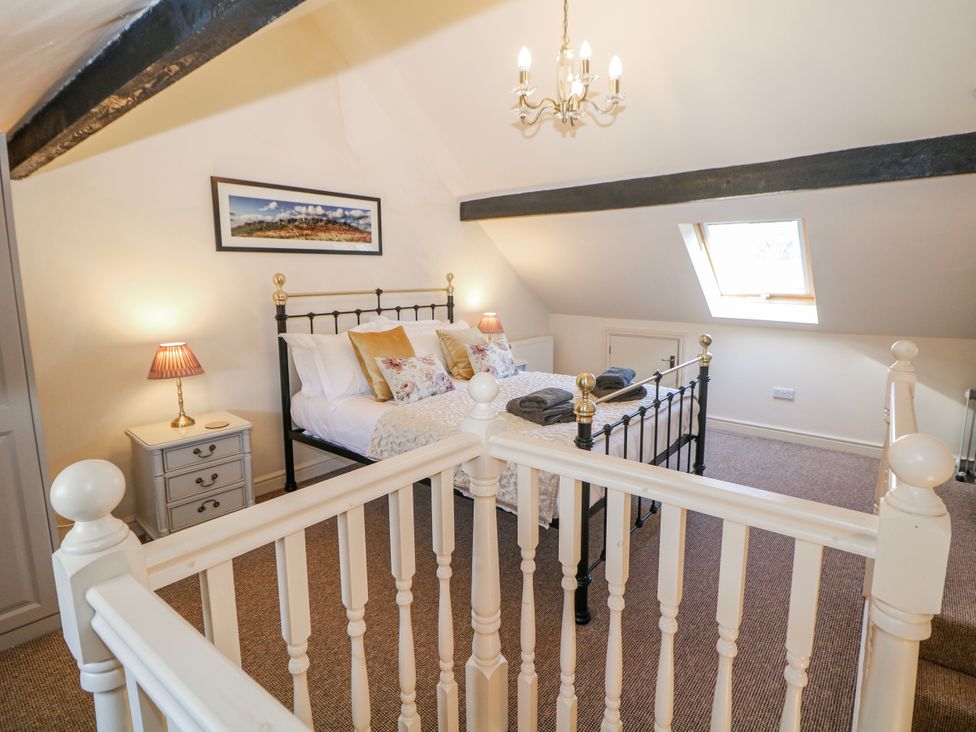 A bedroom with a bed and bedside lamp at Corner Cottage in Tideswell