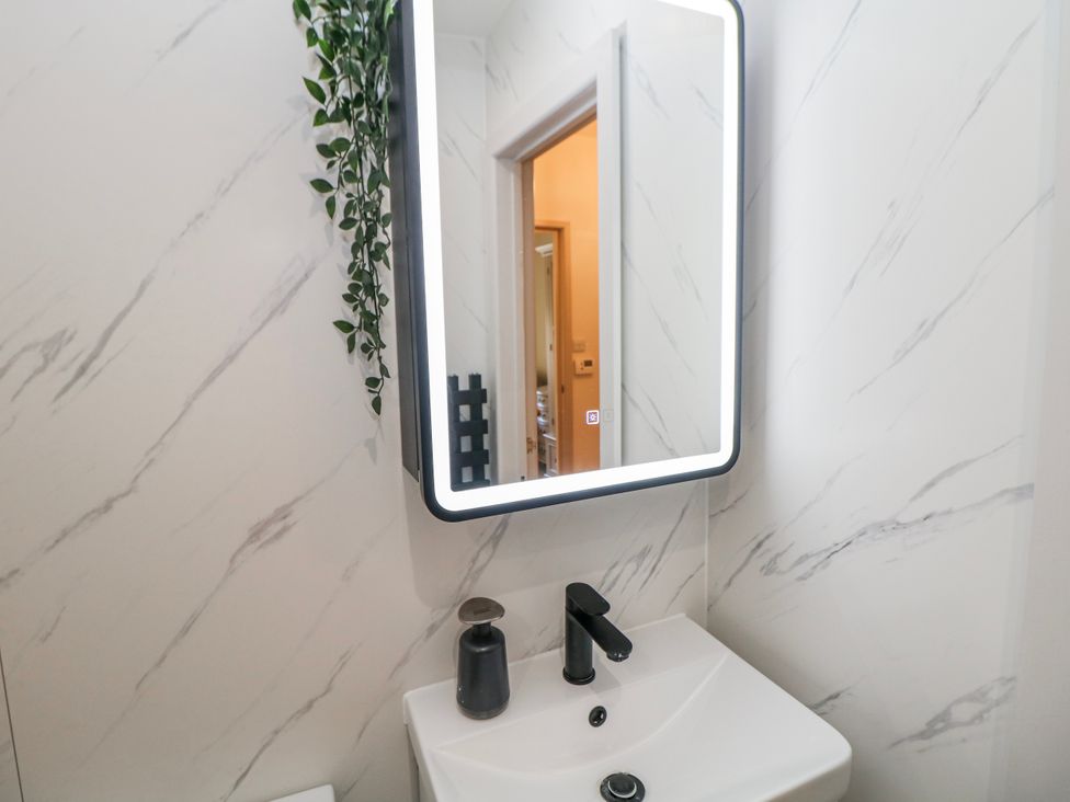 A bathroom with sink and mirror at Corner Cottage in Tideswell
