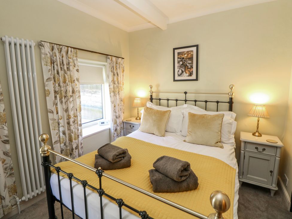 A bedroom with a double bed and nightstands at Corner Cottage in Tideswell