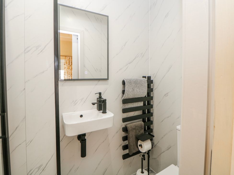 A bathroom with a wash basin and a mirror at Corner Cottage in Tideswell
