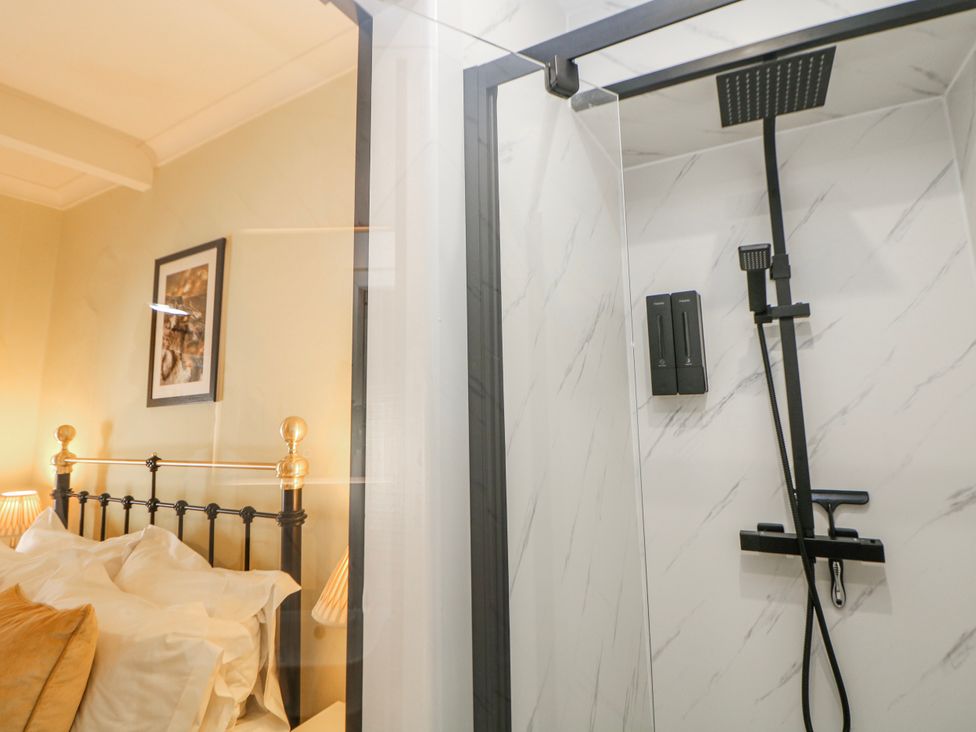 A bedroom with a shower and a bed at Corner Cottage in Tideswell