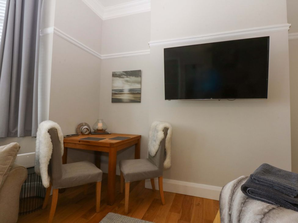 A dining area with a table and chairs at Queens Park in Llandudno