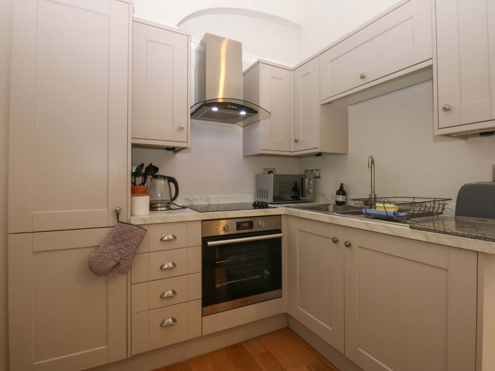 A kitchen with an oven, microwave, and sink at Queens Park in Llandudno