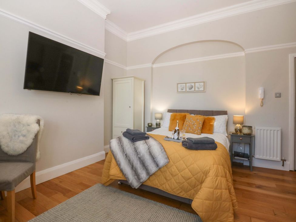 A bedroom with a bed and television at Queens Park in Llandudno