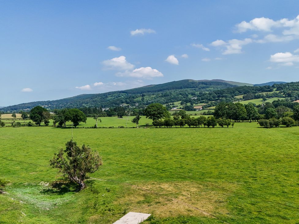 A field with trees and mountains at Hay Store in Corwen