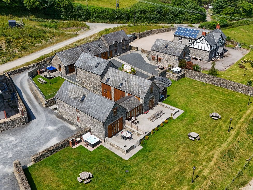 An outdoor area with multiple houses and sitting arrangements at Hay Store in Corwen