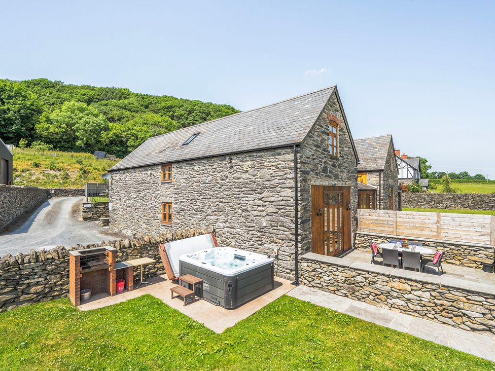 An outdoor area with a hot tub and seating at Hay Store in Corwen