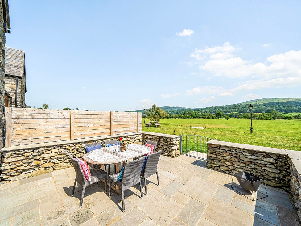 An outdoor patio with a table and chairs at Hay Store in Corwen