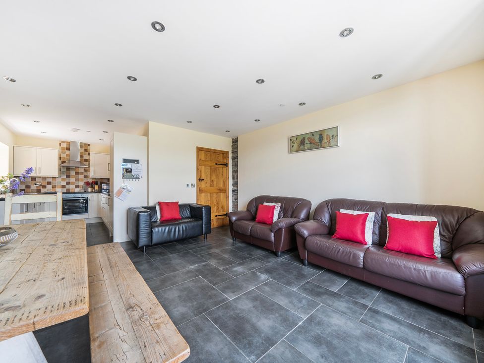 A living room with sofas and a kitchen area at Hay Store in Corwen