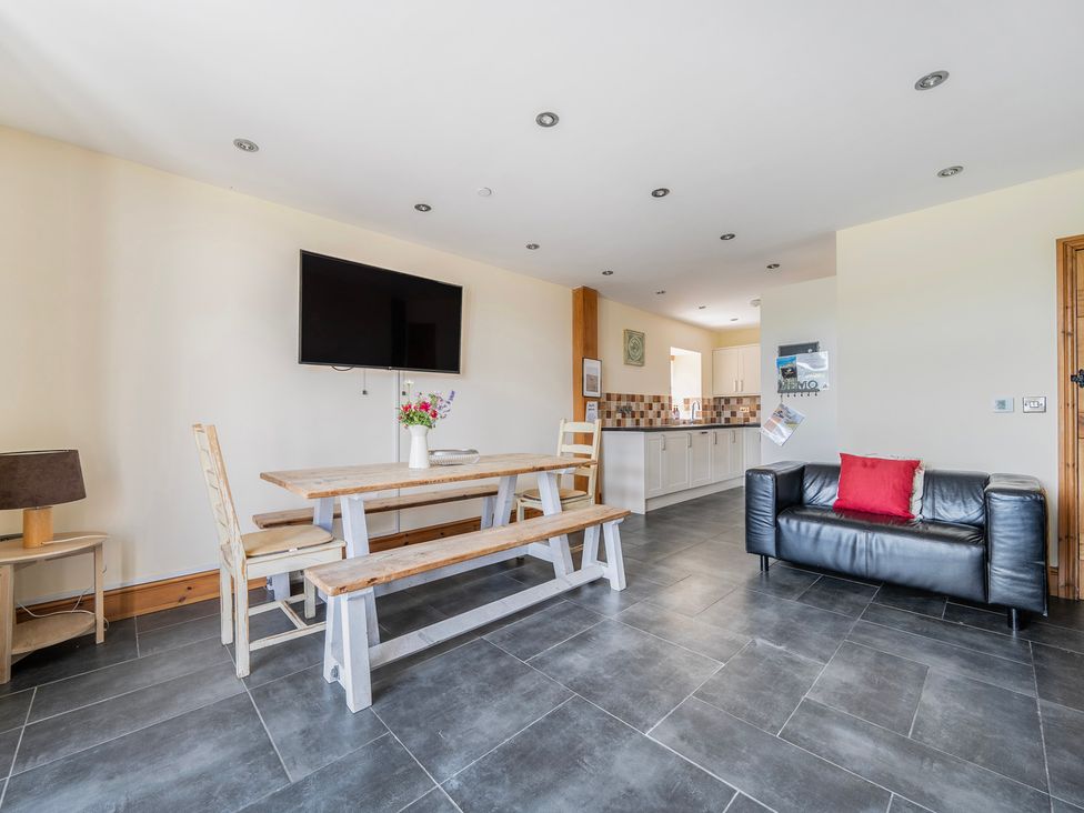 A dining room with a table and sofa at Hay Store in Corwen