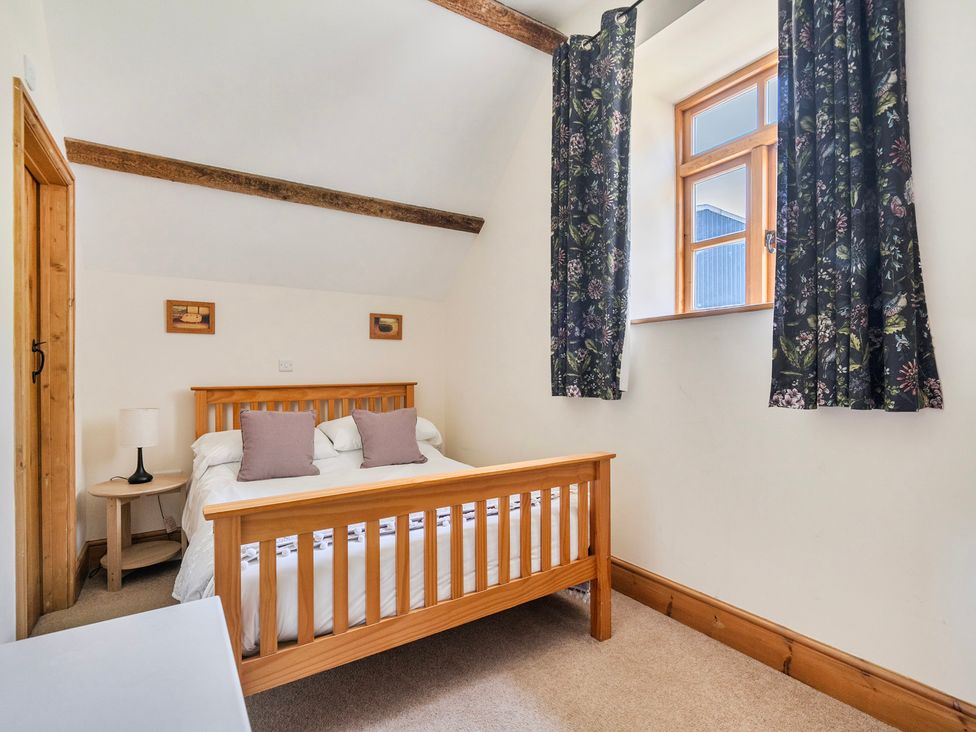 A bedroom with a bed and bedside lamp at Hay Store in Corwen
