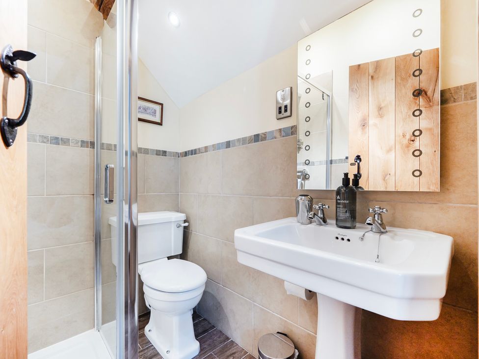A bathroom with a shower, toilet, and sink at Hay Store in Corwen