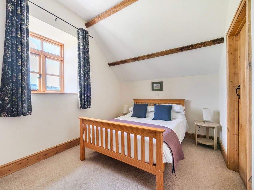 A bedroom with a bed and window at Hay Store in Corwen