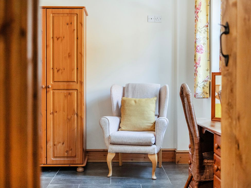 A living room with an armchair and wardrobe at Hay Store in Corwen