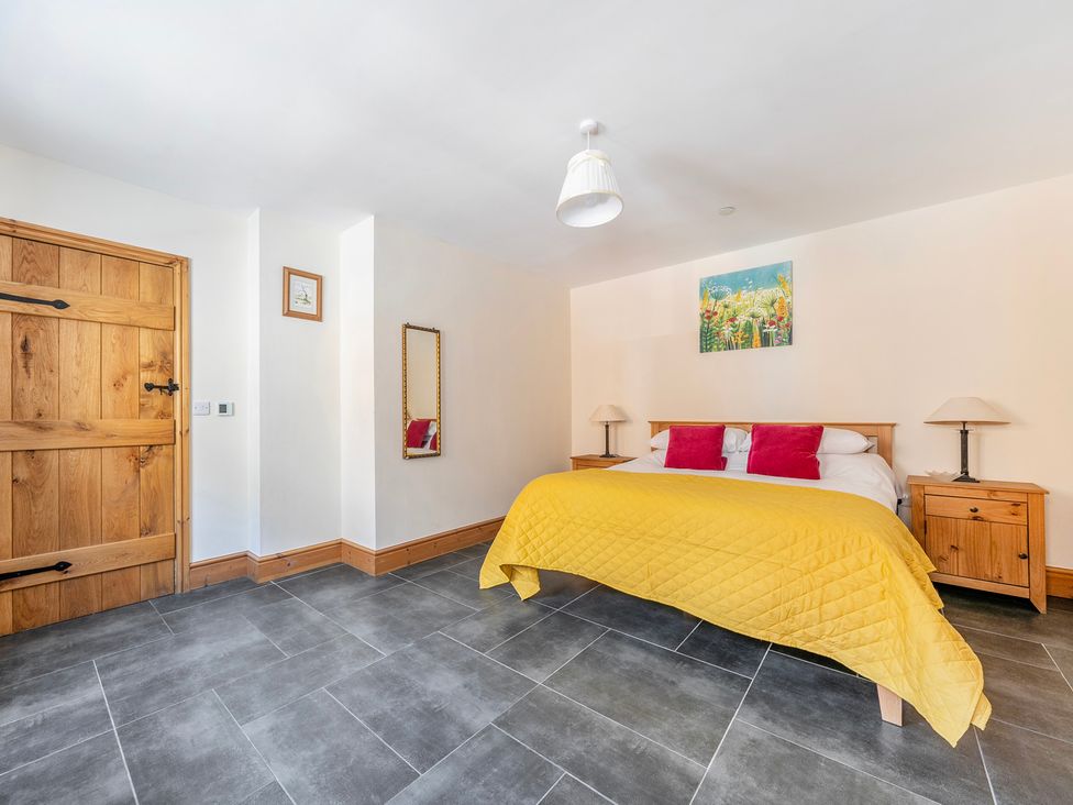 A bedroom with a bed and nightstands at Hay Store in Corwen