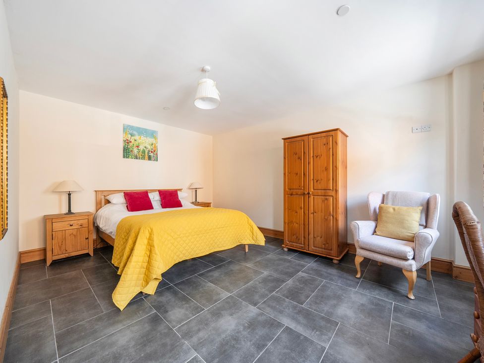 A bedroom with a bed and wardrobe at Hay Store in Corwen