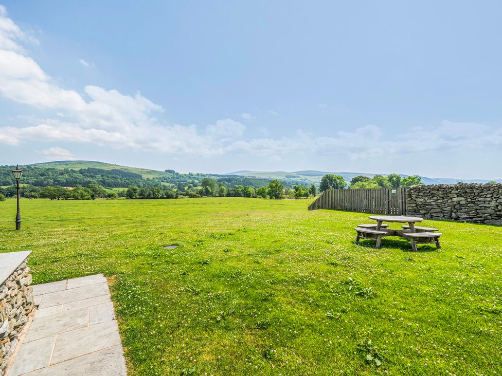 A field with a picnic table and a lamp post at Hay Store in Corwen