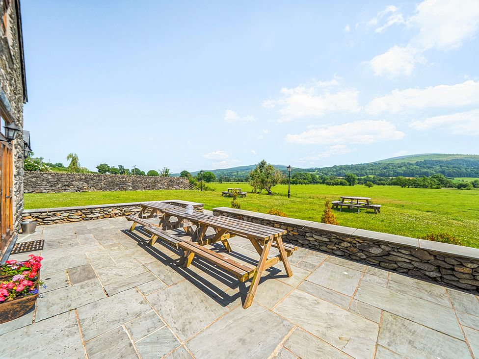 An outdoor space with a picnic table and views of grass at The Barn in Corwen