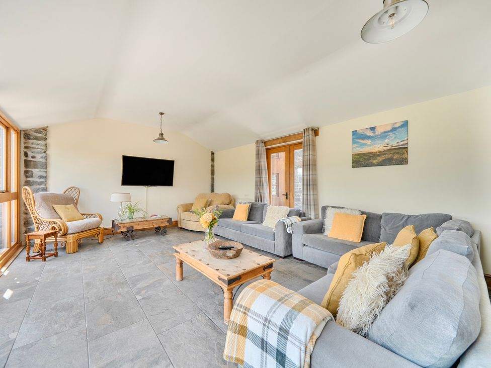 A living room with a sofa and coffee table at The Barn in Corwen