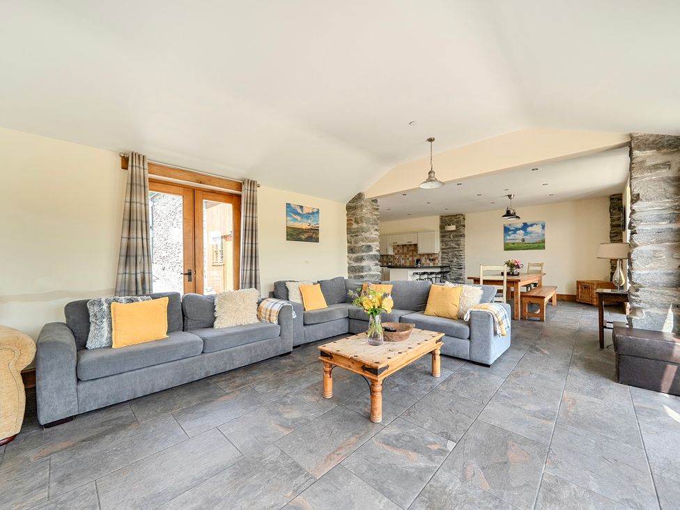 A living room with a sofa and table at The Barn in Corwen