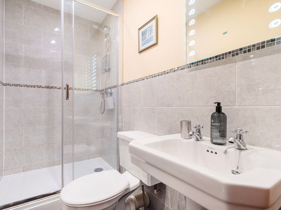 A bathroom featuring a shower, toilet, and sink at The Barn in Corwen