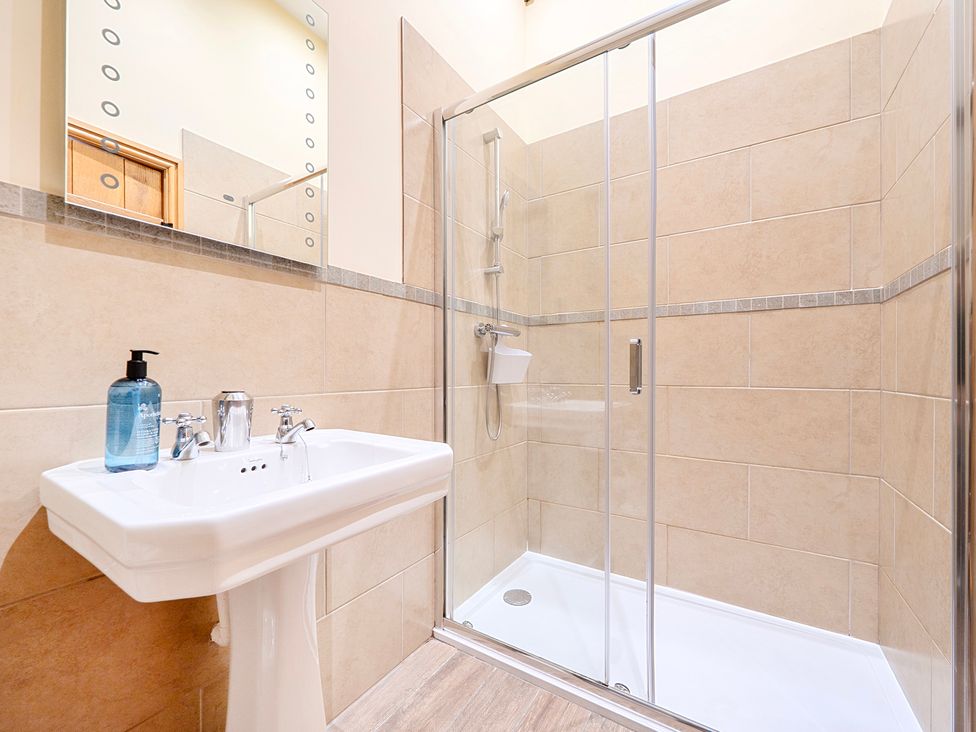 A bathroom with a sink and shower at The Barn in Corwen