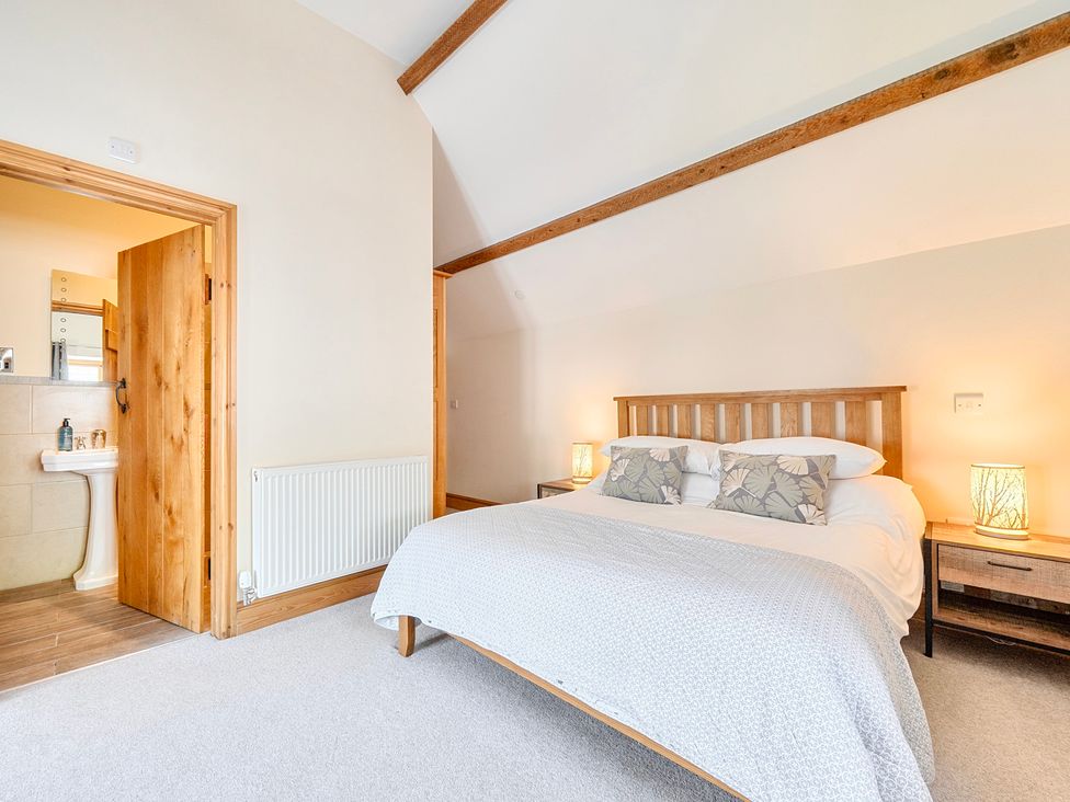 A bedroom with a bed and ensuite bathroom view at The Barn in Corwen