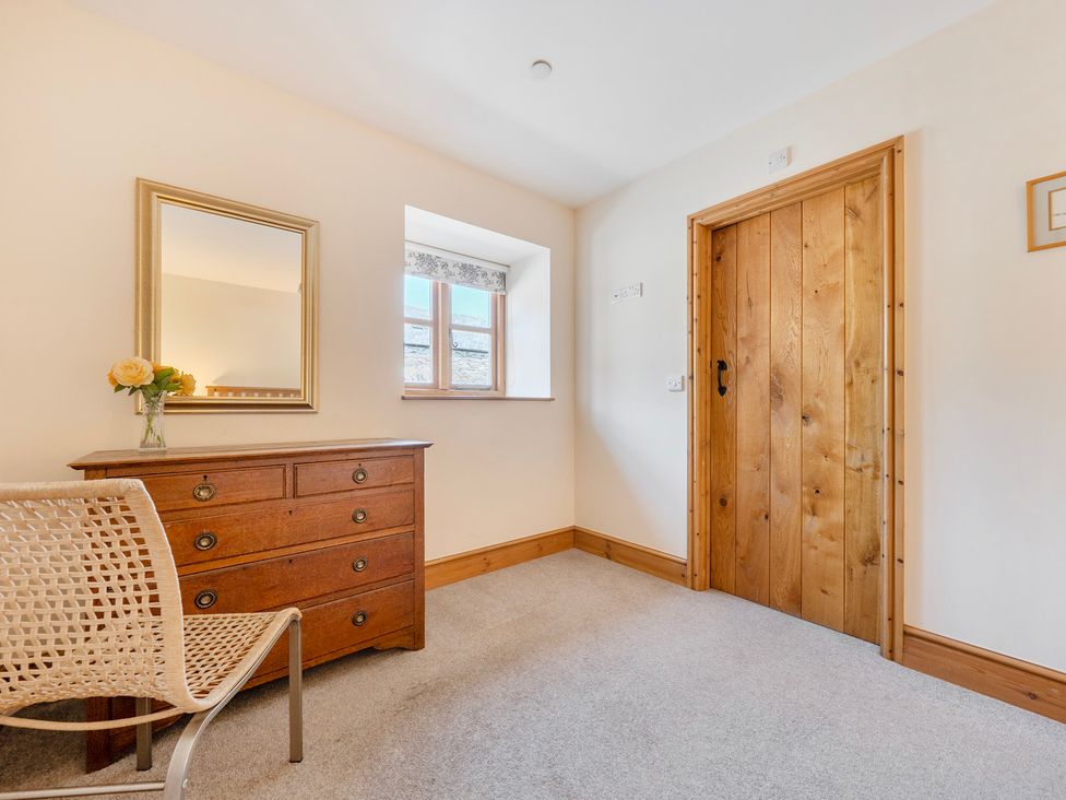 A bedroom with a mirror and a dresser at The Barn in Corwen