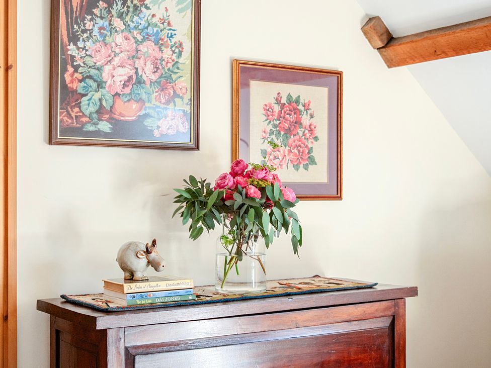 A table with flowers and books at The Barn in Corwen