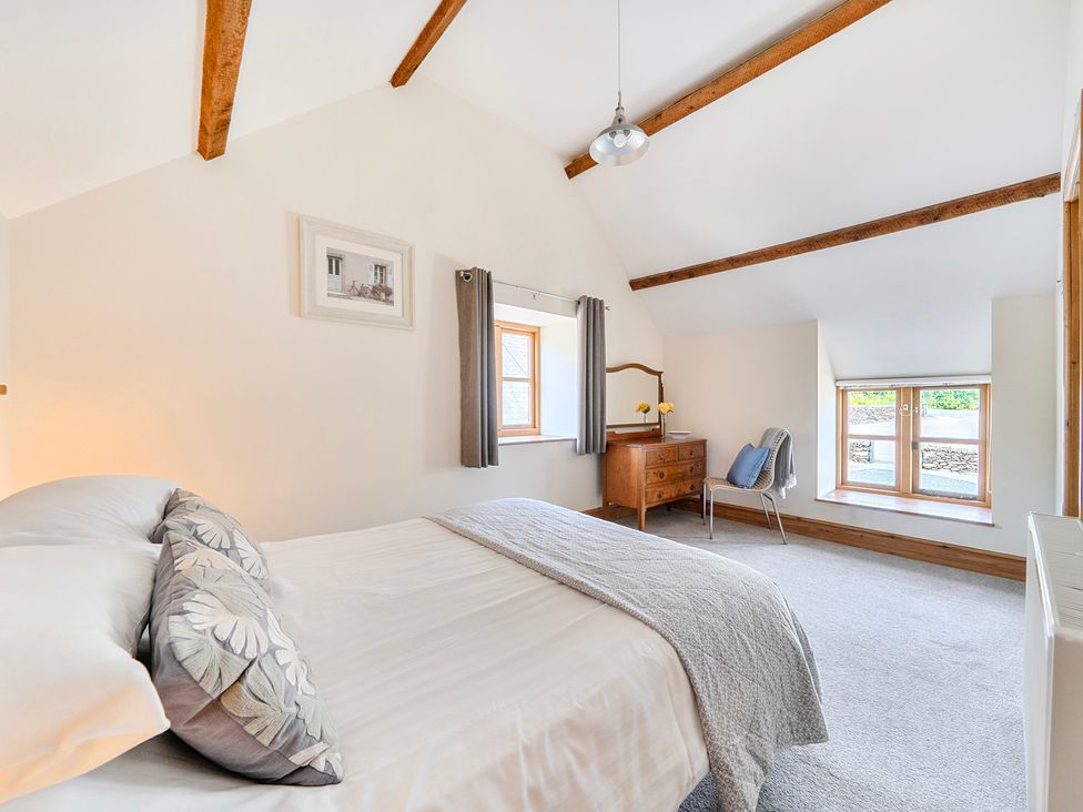 A bedroom with a bed and a window at The Barn in Corwen