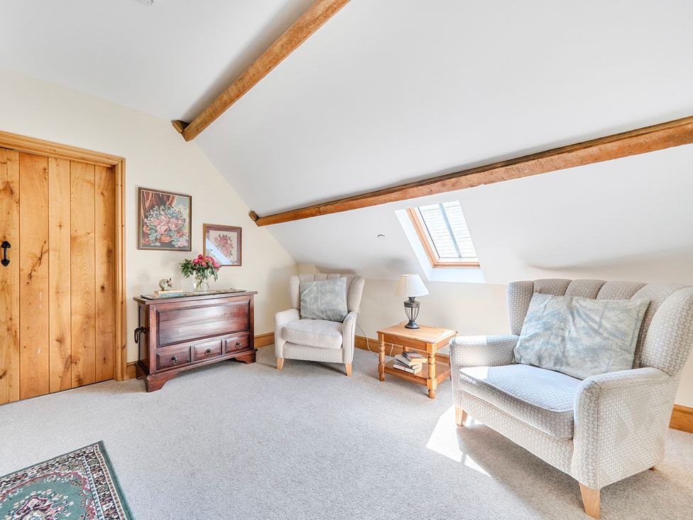 A sitting room with two armchairs and a coffee table at The Barn in Corwen