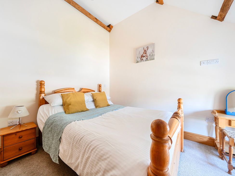 A bedroom with a bed and bedside table at The Barn in Corwen