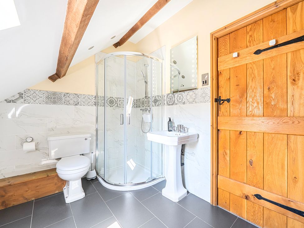 A bathroom with shower, sink and toilet at The Barn in Corwen