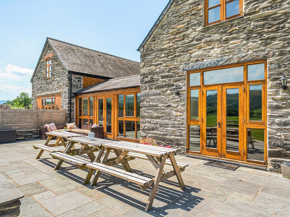 An outdoor patio with a table and chairs at The Barn in Corwen
