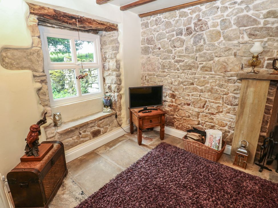 A living room with a television and stone wall at The LA'AL Cragg Kirkby Stephen