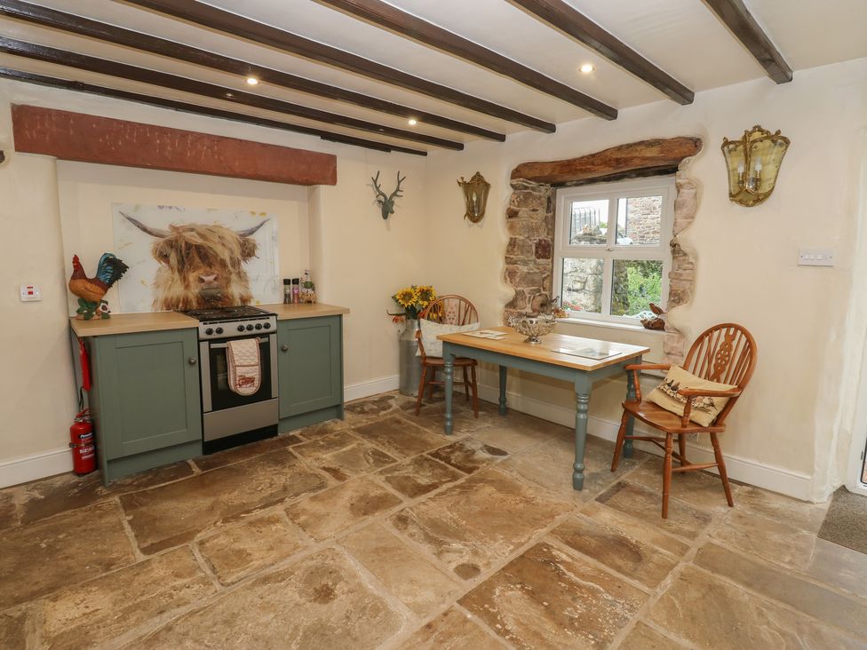 A kitchen with a stove and table at The LA'AL Cragg in Kirkby Stephen