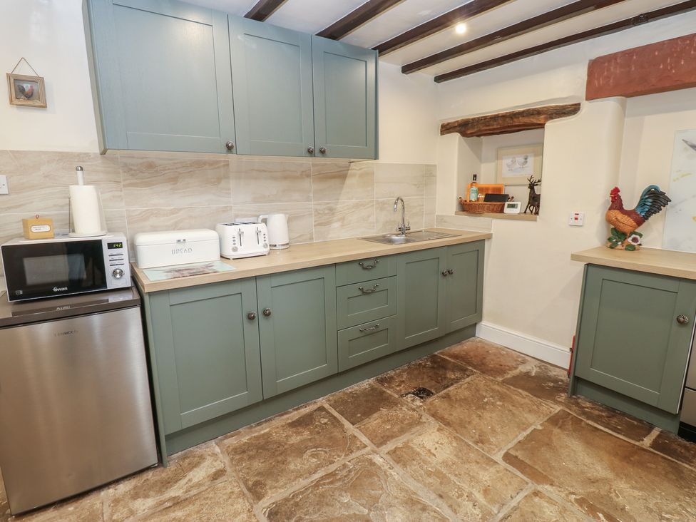A kitchen with cabinets and appliances at The LA'AL Cragg in Kirkby Stephen