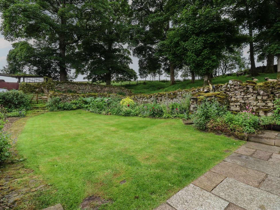 A garden with grass and stone walls at The LA'AL Cragg in Kirkby Stephen