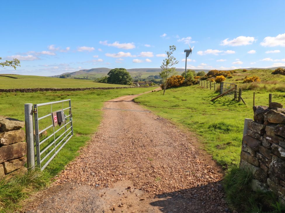 A gravel path leading to a gate with hills in the background at The LA'AL Cragg, Kirkby Stephen