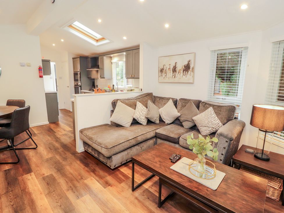 A living room with a sofa and coffee table at Willows Lodge, White Cross Bay, near Windermere