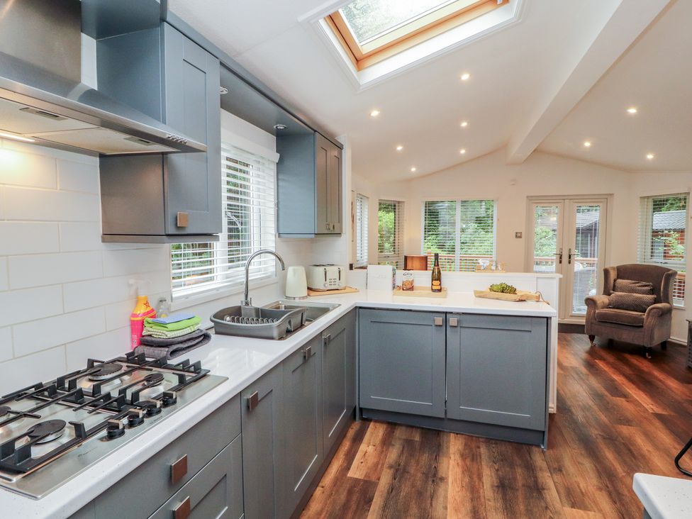 A kitchen with a gas stove and sink at Willows Lodge near Windermere