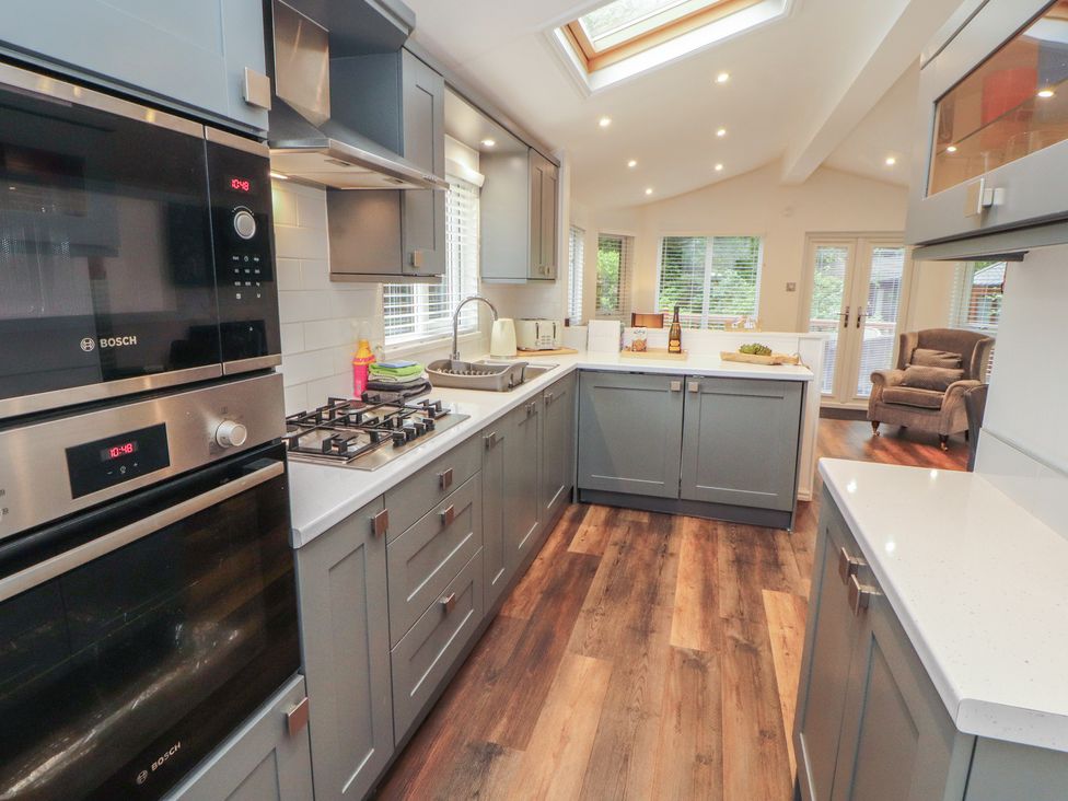 A kitchen with appliances and storage at Willows Lodge, White Cross Bay, near Windermere
