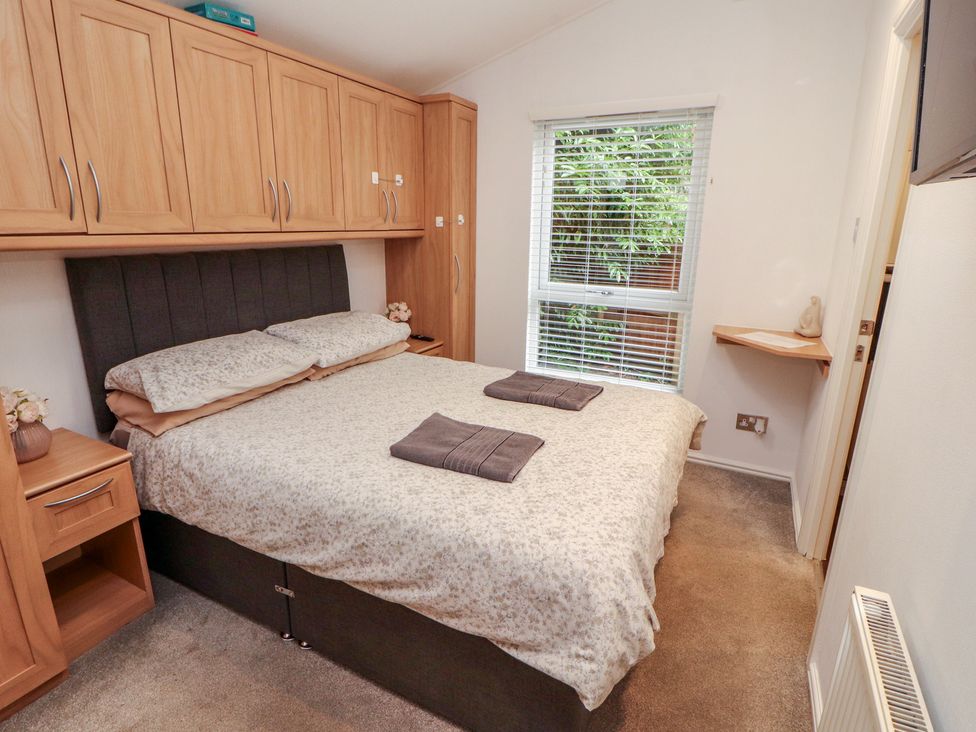 A bedroom with a bed and a window at Willows Lodge White Cross Bay near Windermere