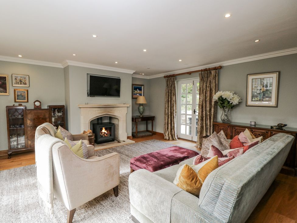 A living room with a fireplace and sofa at The Old Hall in Tetbury