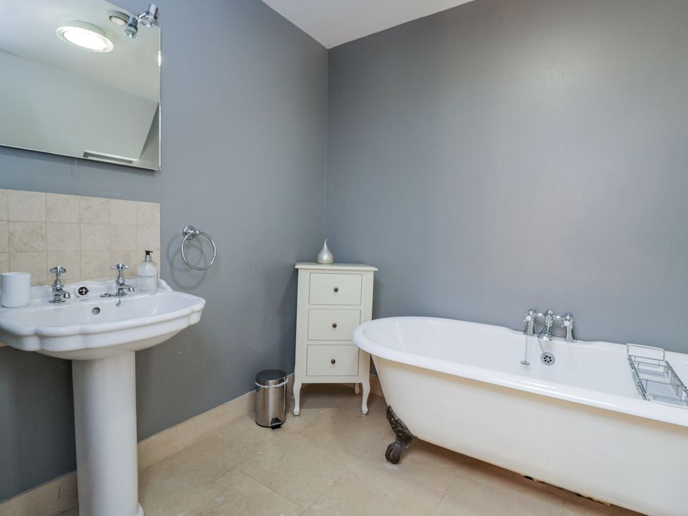 A bathroom with a bathtub and sink at The Old Hall in Tetbury