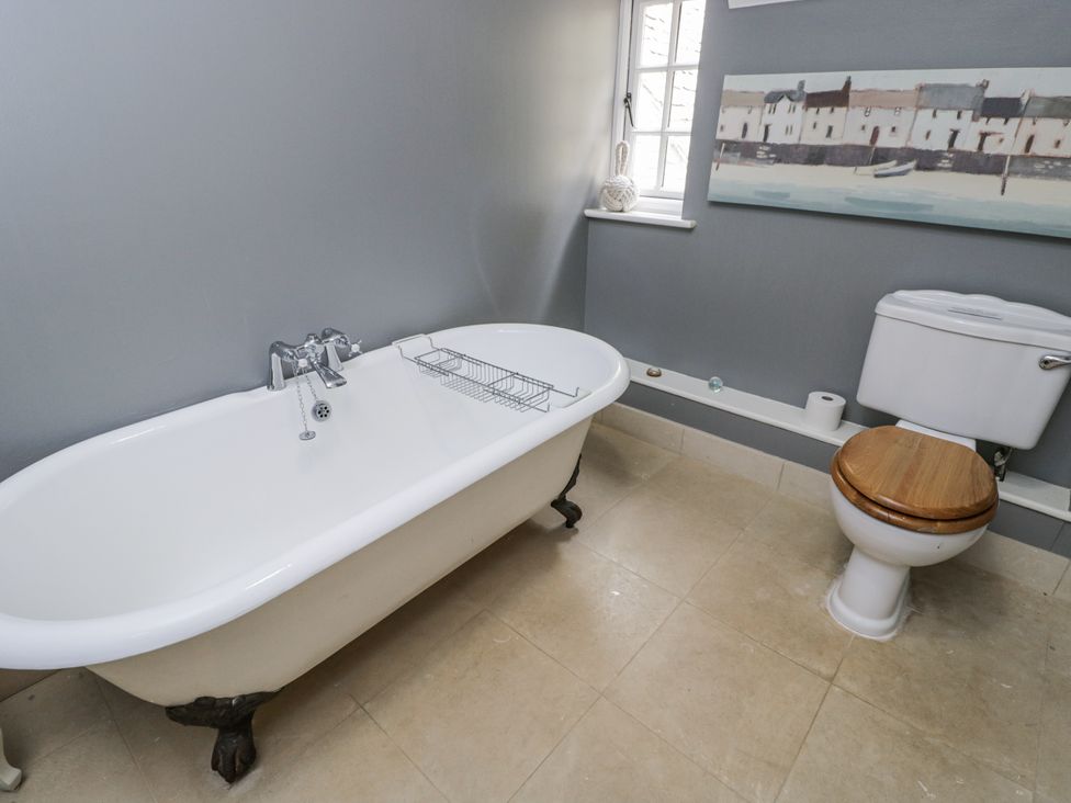 A bathroom with a bathtub and toilet at The Old Hall in Tetbury