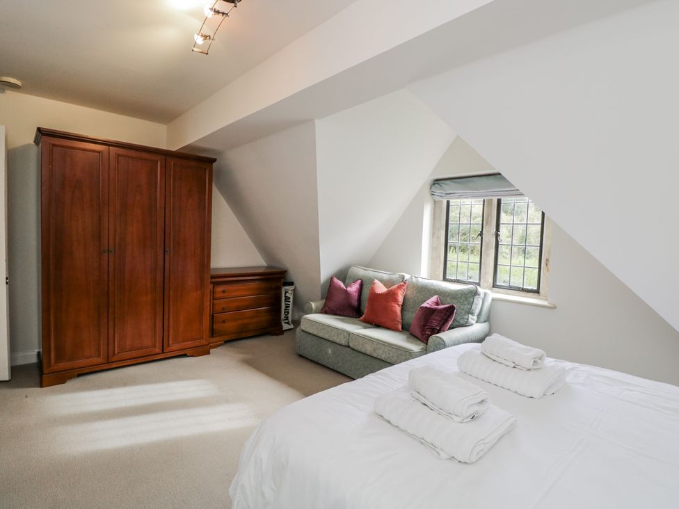 A bedroom with a bed and wardrobe at The Old Hall in Tetbury