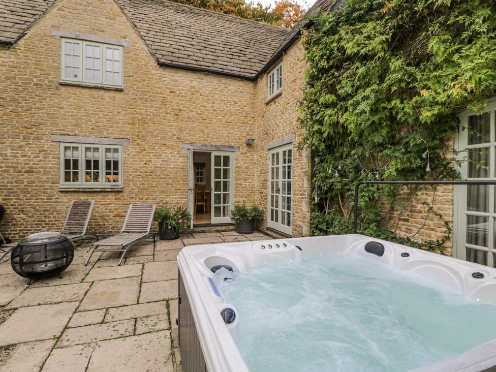 An outdoor area with a hot tub and seating at The Old Hall in Tetbury