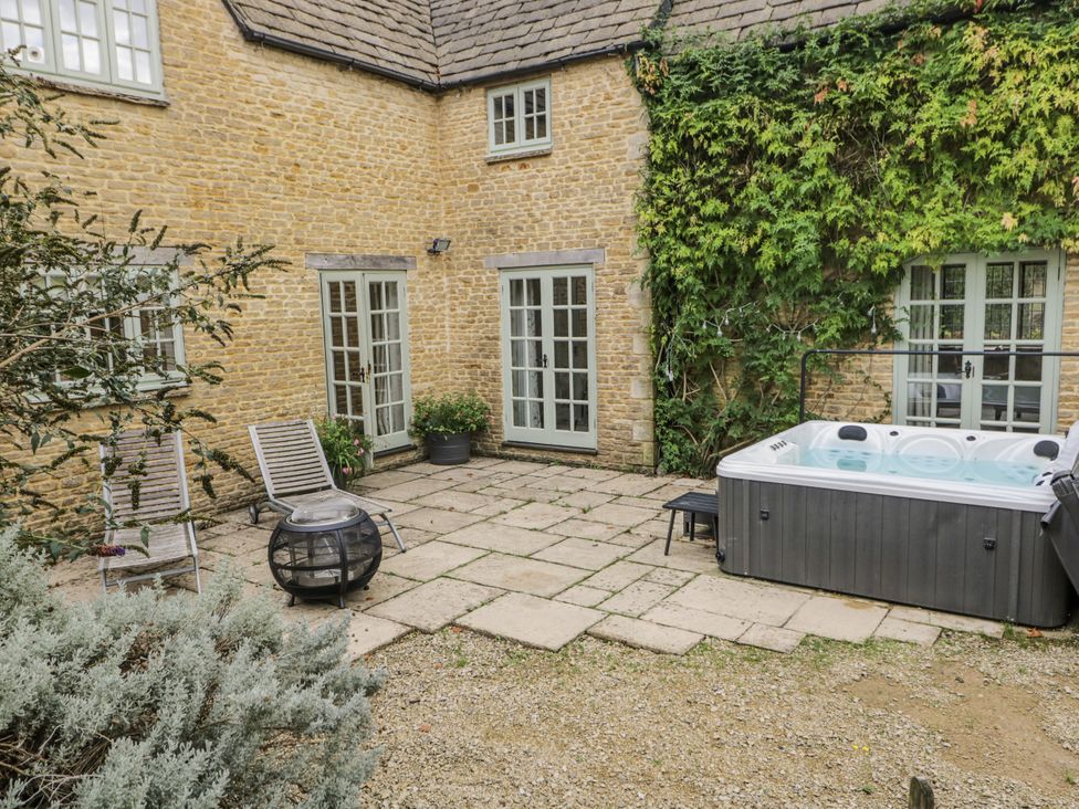 An outdoor area with a hot tub and seating at The Old Hall in Tetbury