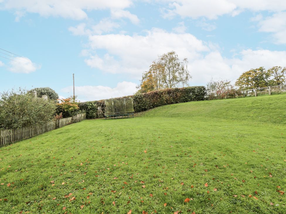 A garden with a trampoline and trees at The Old Hall in Tetbury